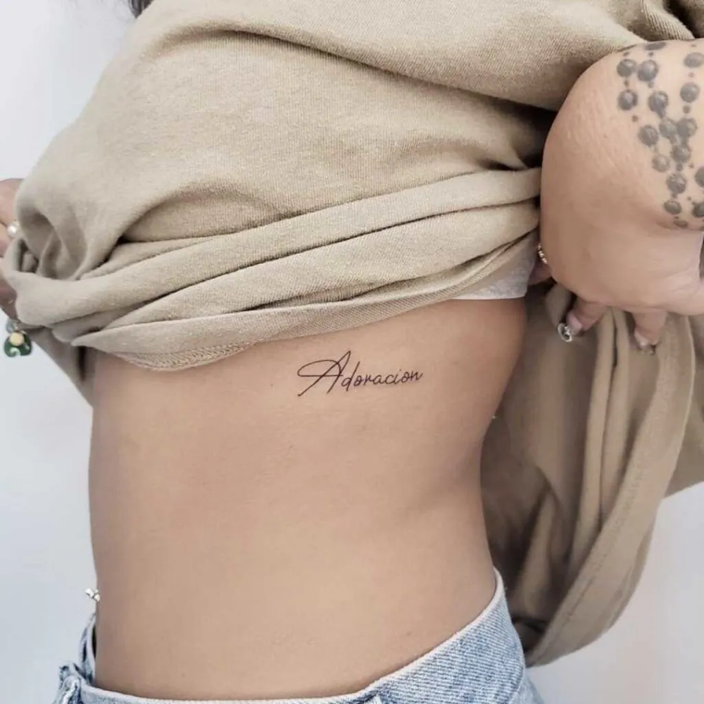 Small Tattoos with Big Meanings – 2025 Guide to Subtle Body Art 12 MantleTattoo Los Angeles tattoo script adoracion 1024x1024 1