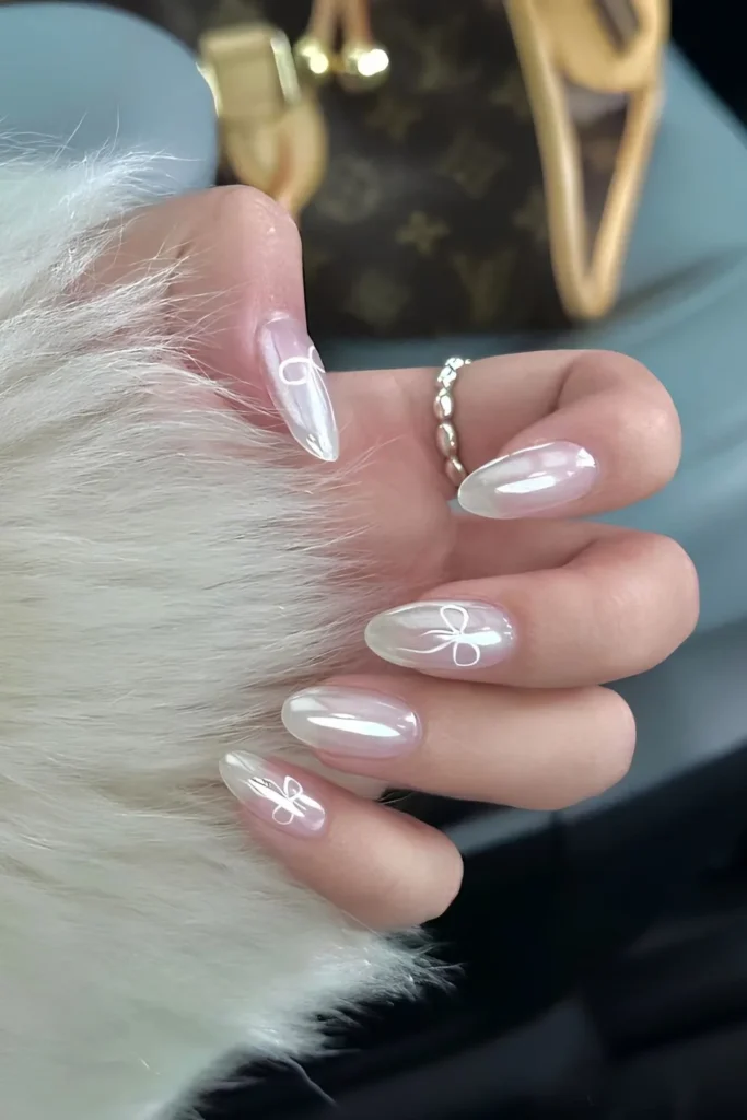 Summer Nail Trends That Will Dominate Instagram in 2025 20 Milky white chrome nails with coquette bows.jpg