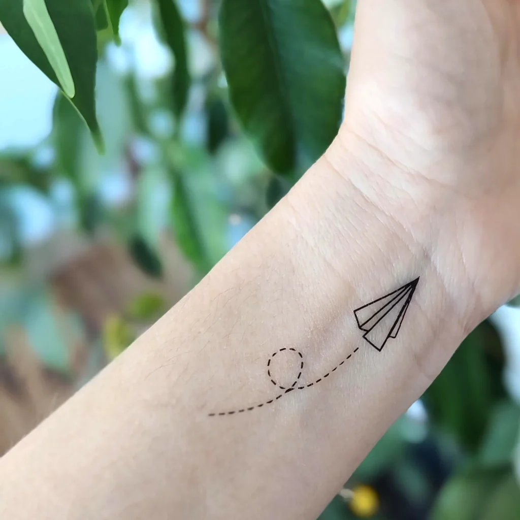 30 Small Tattoo Ideas with Big Meaning (Minimalist Ink Guide) 10 paper plane 2048x